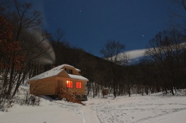 Wooden house for a holiday with illuminated windows clipart