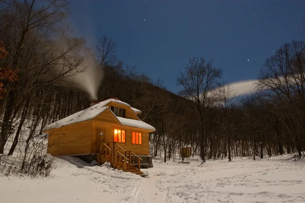 在多雪的森林里的一座小木房子 — 图库照片