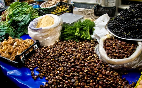 Castañas orgánicas frescas y otras mercancías en un mercado de la calle adentro es — Foto de Stock