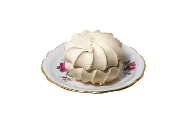 Vainilla dulce merengue beso-pastel en un platillo de porcelana aislado en ba blanca — Foto de Stock