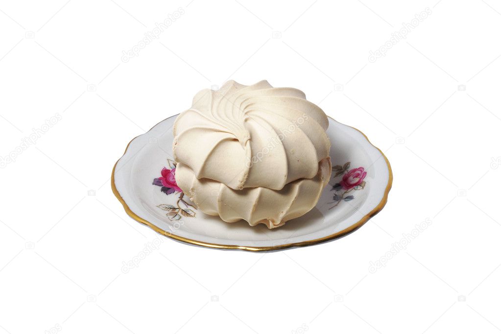 Vanilla sweet meringue kiss-cake on a porcelain saucer isolated on white ba