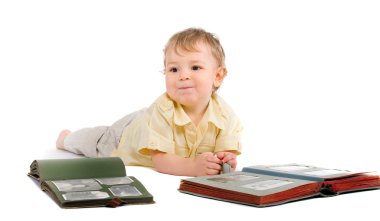 Boy lies on a floor with old photo albums over white clipart