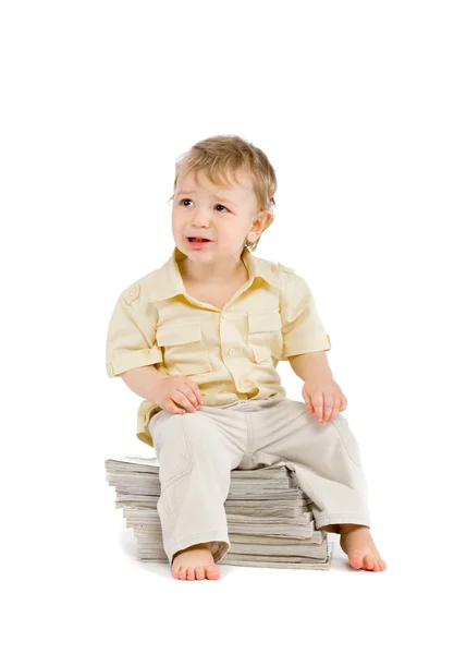 Malý chlapec sedí na hromadě knih — Stock fotografie