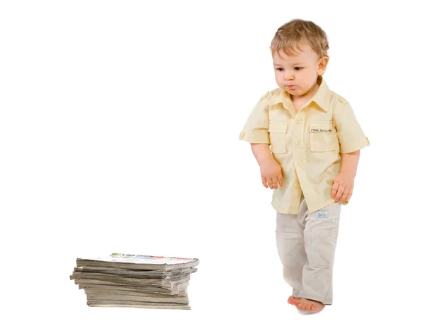 Der Kleine Junge Blickt Auf Einen Stapel Bücher Über Weiß lizenzfreie Stockbilder