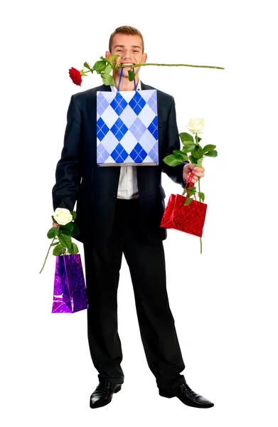 Ung man med rose och shopping väska — Stockfoto