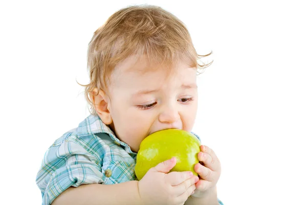 Vackra pojke äter grönt äpple. Stockbild