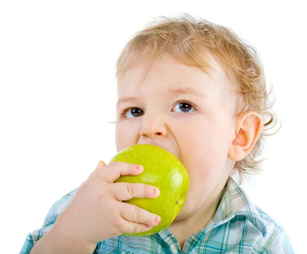 Beautiful baby boy eats green apple. Royalty Free Stock Images