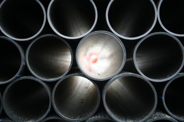 Gray pvc pipes stacked in construction site clipart