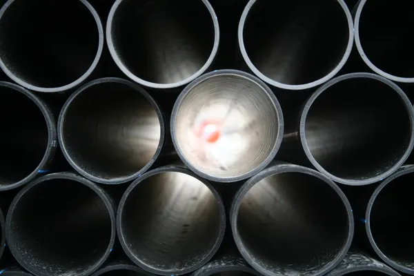 Tubos de PVC cinza empilhados no canteiro de obras — Fotografia de Stock