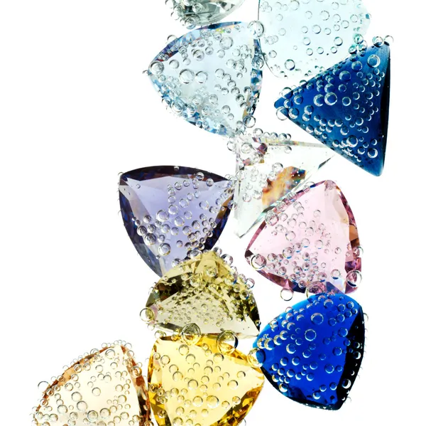 Multi-colored gems falling into water isolated on white. — Stock Photo, Image