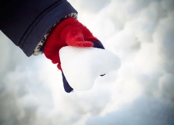 Coração de neve na mão da criança — Fotografia de Stock