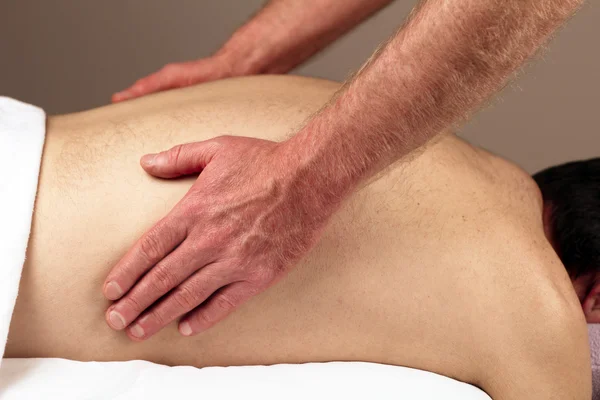 Homem massageando lados traseiros — Fotografia de Stock