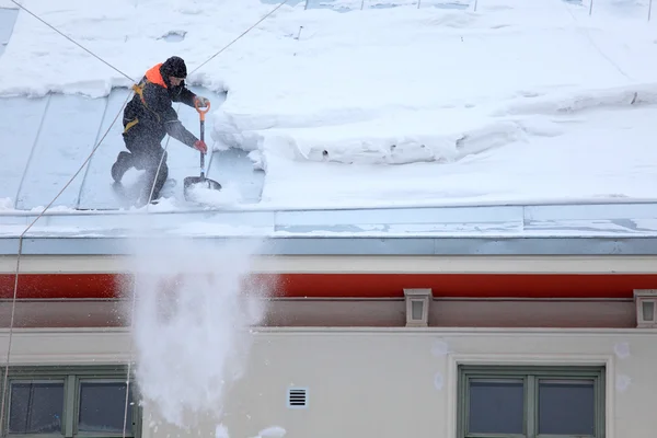 Άνθρωπος αποψύχοντας μια χιονισμένη στέγη — Φωτογραφία Αρχείου