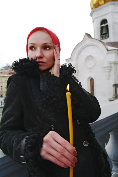 La muchacha el cristiano con la vela contra el templo, Moscú — Foto de Stock