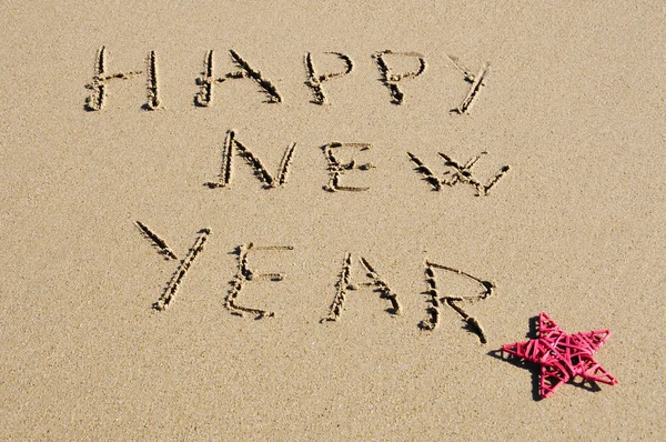 Sentencia feliz año nuevo escrito en la arena — Foto de Stock