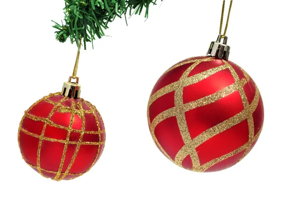 Ένα ζευγάρι κόκκινες και χρυσές μπάλες Χριστούγεννα που κρέμεται από ένα χριστουγεννιάτικο δέντρο — Φωτογραφία Αρχείου