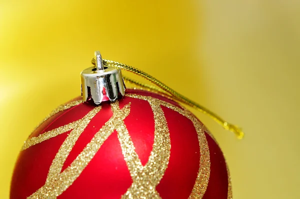 Czerwoną i złotą piłkę Bożego Narodzenia na złotym tle — Zdjęcie stockowe
