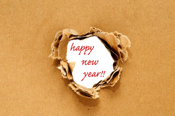 Frohes neues Jahr auf einem Loch auf braunem Papphintergrund geschrieben — Stockfoto