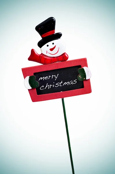 Vrolijk kerstfeest geschreven in een schoolbord met een sneeuwpop — Stockfoto