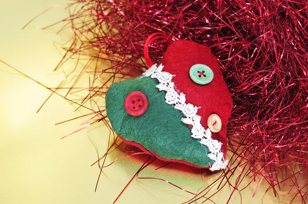 Un ornamento natalizio e fili di lame rossi su uno sfondo dorato — Foto Stock