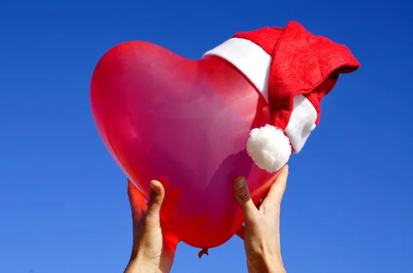 A heart-shaped balloon with a santa hat — Stock Photo, Image