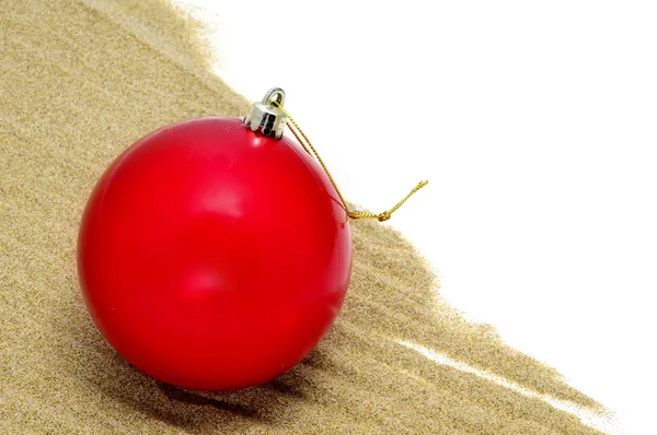 A red christmas ball on the sand — Stock Photo, Image