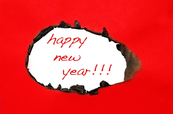 Felice anno nuovo scritto su un buco su uno sfondo di cartone rosso — Foto Stock