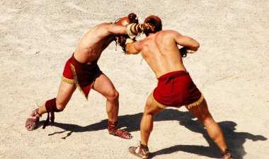 Two gladiators fighting on the arena of an amphitheater clipart