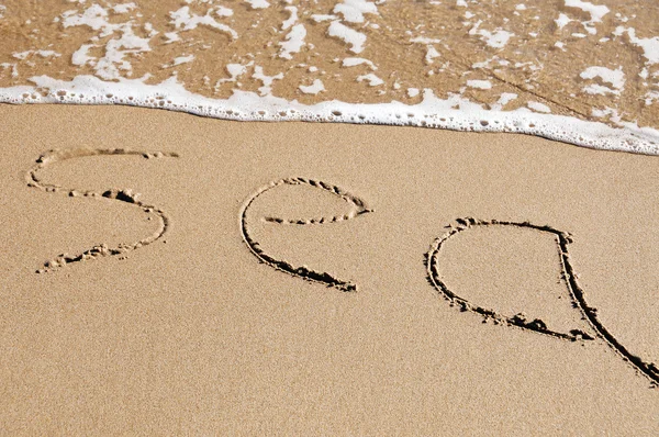 ビーチの砂に書かれた単語海 — ストック写真