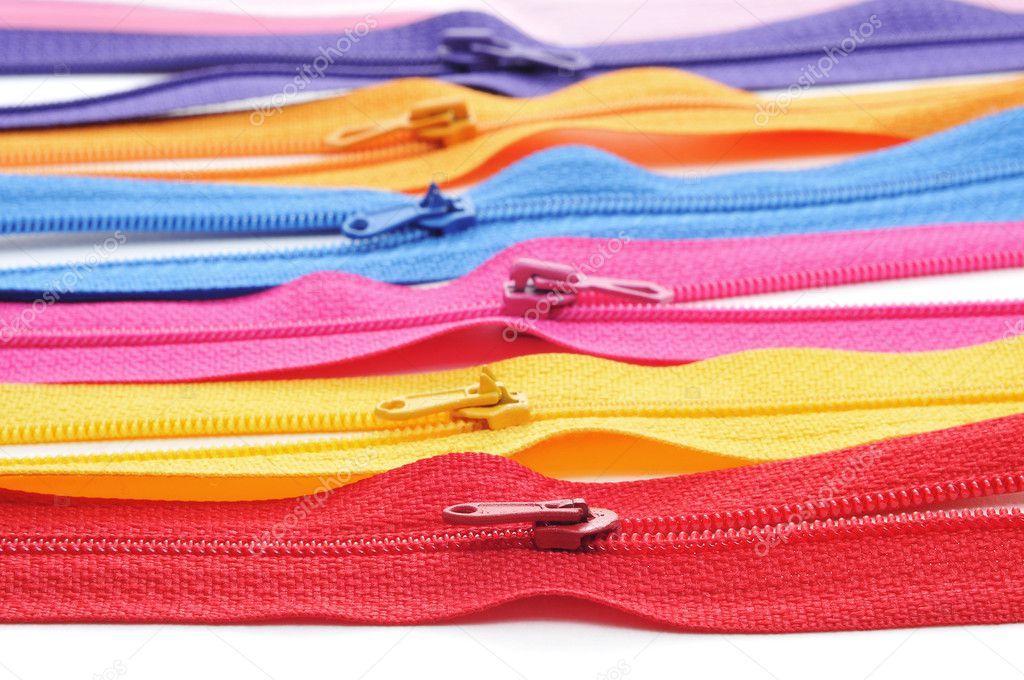 Zippers of many colors on a white background