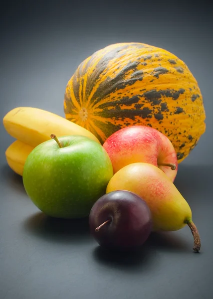 新鮮で熟したカラフルな果物 りんご バナナ メロンの暗い背景上に配置 — ストック写真