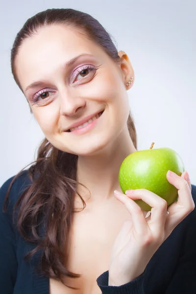 Beautiful young woman holding an apple — Stock Photo, Image