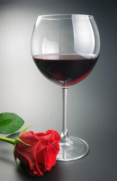stock image Glass of red wine and rose flower