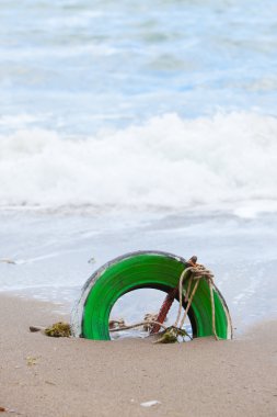 kum deniz kenarında yeşil lastik