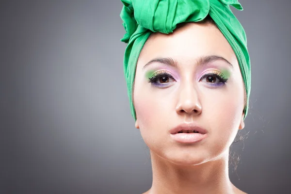 Красивая женщина с розово-зеленым макияжем в зеленой шляпе — стоковое фото