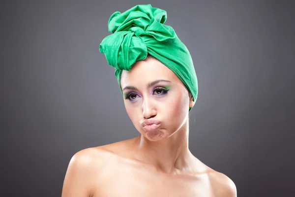 Ideges, fiatal nő, rózsaszín-zöld smink zöld kalapban — Stock Fotó