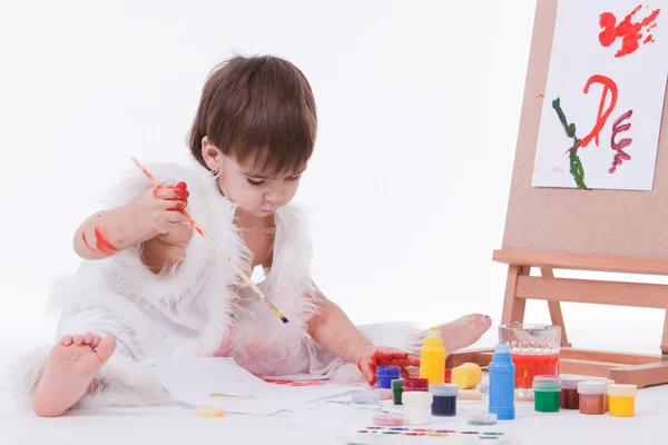 Cute little creative boy in white painting with brush — Stock Photo, Image