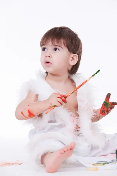 Retrato de bebê bonito segurando escova com as mãos pintadas — Fotografia de Stock