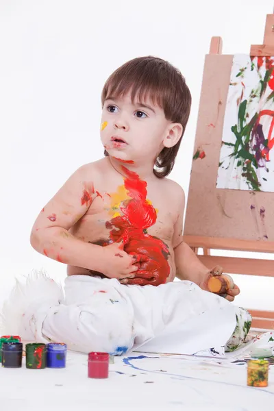 Портрет милого ребенка, разбрасывающего краски руками на животе — стоковое фото