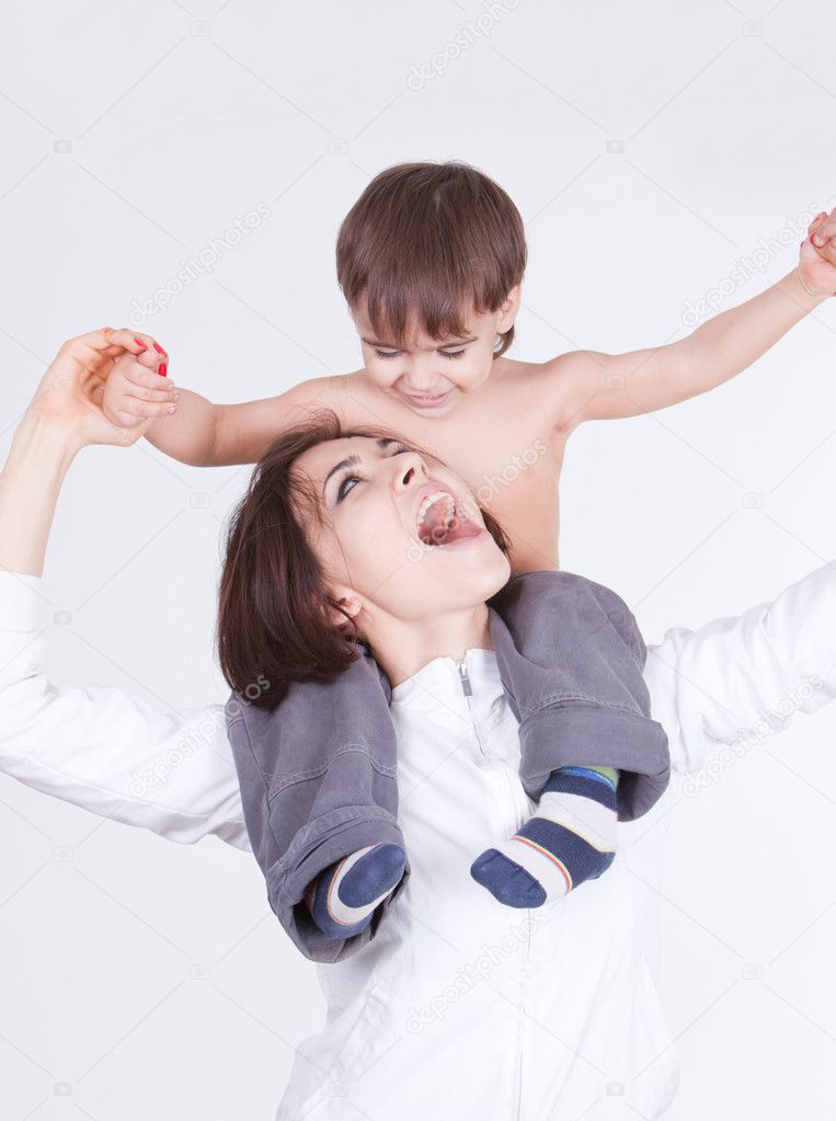 Happy smiling mother playing with her son on her shoulders