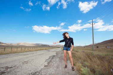 Woman tries to stop the car on old road clipart