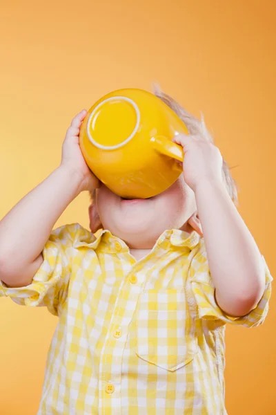 Funny child drink from big yellow cup — Stock Photo, Image