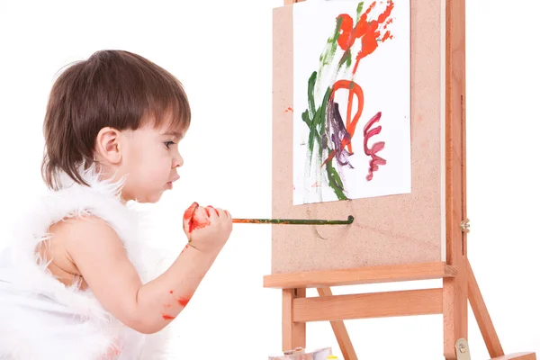 Cute baby in white painting with brush on easel — Stock Photo, Image