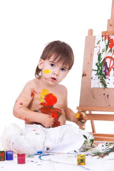 Смешной ребенок разбрасывает краски руками на живот — стоковое фото