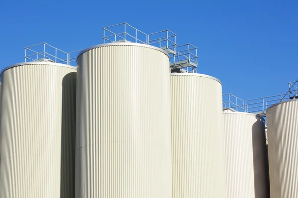 stock image Refinery oil storage tanks and blue sky in background