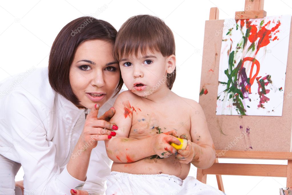 Mom and son paint near easel, mom pointing to camera