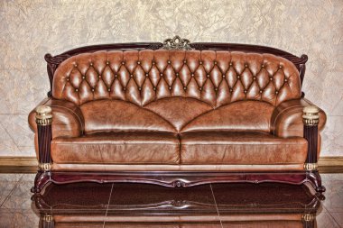 Antique leather brown sofa in the room clipart