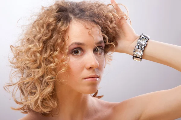 Linda jovem loira encaracolado mulher segurando o cabelo com as mãos — Fotografia de Stock