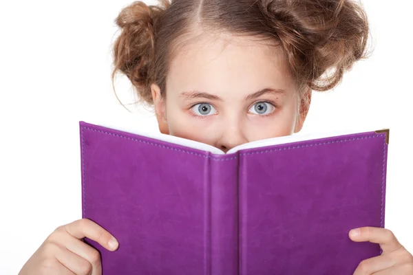 stock image Cute little girl peeping behind the book looking at camera