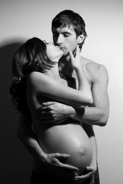 Glücklich küssendes Paar umarmt, Frau schwanger — Stockfoto